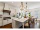 Bright kitchen with white cabinetry, stainless appliances, large center island and open dining space at 6715 Pond Rd, Cumming, GA 30040