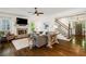 Inviting living room featuring a stone fireplace, hardwood floors, and staircase access at 6715 Pond Rd, Cumming, GA 30040