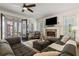 Elegant living room featuring a stone fireplace, large sectional sofa, and French doors leading to a screened-in porch at 6715 Pond Rd, Cumming, GA 30040