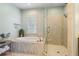 Spa-like bathroom with a soaking tub, glass shower, and elegant fixtures for a relaxing experience at 6715 Pond Rd, Cumming, GA 30040