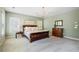Spacious main bedroom with neutral carpet, large windows, and a decorative chandelier lighting at 6715 Pond Rd, Cumming, GA 30040