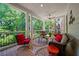 Inviting covered porch featuring comfortable seating, decorative rug, and serene views of lush greenery at 6715 Pond Rd, Cumming, GA 30040