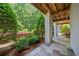 Covered porch with stone flooring and landscaping view at 6715 Pond Rd, Cumming, GA 30040