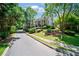 Serene street view showcasing the charming two-story home surrounded by lush trees and manicured lawns at 6715 Pond Rd, Cumming, GA 30040