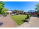 Landscaped plaza with green lawn, outdoor seating, and string lights among commercial buildings at 6715 Pond Rd, Cumming, GA 30040