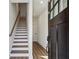 Bright entryway with wood floors, white walls, a staircase, and modern black hardware at 101 Mission Se Way # 101, Atlanta, GA 30315