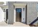 Inviting front door of unit 106 with gray brick, a porch light, and modern hardware at 101 Mission Se Way # 101, Atlanta, GA 30315