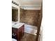 Bathroom features a shower-tub combo with brown tile backsplash and a vanity with a white sink at 2195 Wilson Rd, Conyers, GA 30012