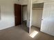 Bedroom with a closet and a door leading to another room or hallway with neutral carpet at 2195 Wilson Rd, Conyers, GA 30012