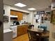 Kitchen features wood cabinets, white appliances, and a dining table in a cozy space at 2195 Wilson Rd, Conyers, GA 30012