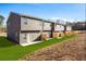 Rear view of townhomes featuring tidy lawns and backyard areas at 235 Ivey Ter, Temple, GA 30179