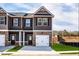 Newly constructed townhome with a private entrance, attached garage, and front yard landscaping at 235 Ivey Ter, Temple, GA 30179