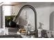 Close-up of a modern kitchen sink with a pull-down faucet and granite countertops at 235 Ivey Ter, Temple, GA 30179