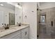 Modern bathroom with double sinks, granite countertop, framed mirror and frameless glass shower at 103 Mission Se Way # 103, Atlanta, GA 30315