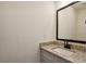 Clean and modern bathroom vanity with granite countertop, a framed mirror, and neutral color scheme at 103 Mission Se Way # 103, Atlanta, GA 30315