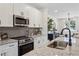 A well-lit kitchen featuring granite countertops, stainless steel appliances, and modern cabinets with a breakfast bar at 103 Mission Se Way # 103, Atlanta, GA 30315