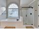 Beautiful bathroom features a shower with glass door and a soaking tub under a large window at 2049 Mclain Nw Rd, Acworth, GA 30101