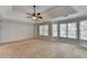 A spacious primary bedroom features a tray ceiling, carpet, ceiling fan, and large windows at 2049 Mclain Nw Rd, Acworth, GA 30101