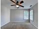 A well-lit bedroom features neutral walls, a ceiling fan, carpet, and a window with blinds at 2049 Mclain Nw Rd, Acworth, GA 30101