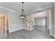 Well lit dining room featuring gray laminate floors, neutral paint, and entry to living room and staircase at 2049 Mclain Nw Rd, Acworth, GA 30101