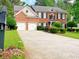 Charming two-story brick home featuring a two-car garage and a well-manicured front yard with lush landscaping at 2049 Mclain Nw Rd, Acworth, GA 30101