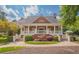 Elegant brick home with a grand porch, white columns, and manicured landscaping, exuding timeless charm and sophistication at 2049 Mclain Nw Rd, Acworth, GA 30101