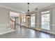 Bright, open foyer with gray laminate flooring, a staircase, and views of the front entry and living room at 2049 Mclain Nw Rd, Acworth, GA 30101