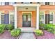 Close-up of a brick home's front entrance with white columns, dark shutters, and trimmed greenery at 2049 Mclain Nw Rd, Acworth, GA 30101