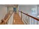 Upstairs hallway with wood floors, railings, and a window at 2049 Mclain Nw Rd, Acworth, GA 30101