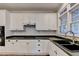 White cabinetry kitchen features stainless steel appliances, dark counters, and undermount sink at 2049 Mclain Nw Rd, Acworth, GA 30101
