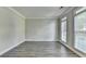 Bright living room with three large windows, hardwood flooring, crown molding, and neutral paint at 2049 Mclain Nw Rd, Acworth, GA 30101