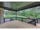Back deck features dark wood railing, wood flooring, a ceiling and a view to the green backyard at 3203 Bold Springs Rd, Dacula, GA 30011