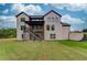 Rear exterior features a manicured backyard with a spacious lawn, back patio and stairs to back deck at 3203 Bold Springs Rd, Dacula, GA 30011