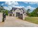 View of the home and gated driveway, showing its architectural details and landscaping at 3203 Bold Springs Rd, Dacula, GA 30011