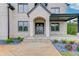 Close-up of the front entrance with stone steps, a modern door, and tasteful landscaping at 3203 Bold Springs Rd, Dacula, GA 30011