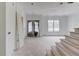 Unfinished living room showcasing paneled wall, large windows and staircase at 3203 Bold Springs Rd, Dacula, GA 30011