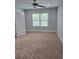 Neutral bedroom with carpet flooring, featuring a ceiling fan, bright window, and white trim at 4075 Sw Fairburn Sw Ave, Atlanta, GA 30331