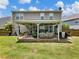 Exterior view of the home's covered patio and backyard, featuring a well-manicured lawn at 6215 Barley Sq, Sugar Hill, GA 30518