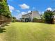 Large, grassy backyard with a covered patio area perfect for entertaining and relaxation at 6215 Barley Sq, Sugar Hill, GA 30518