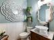 Well-decorated half bathroom with modern fixtures, wainscoting, stylish mirror, and contemporary design at 6215 Barley Sq, Sugar Hill, GA 30518
