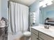 Cozy bathroom showcasing a shower with a striped curtain, neutral paint, and towels on a decorative rack at 6215 Barley Sq, Sugar Hill, GA 30518