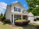 Inviting two-story home featuring stone and siding accents, lush landscaping, and a cozy covered porch at 6215 Barley Sq, Sugar Hill, GA 30518