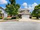 Charming home with a well-manicured lawn, mature trees, and a two-car garage on a sunny day at 6215 Barley Sq, Sugar Hill, GA 30518