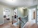 Upstairs hallway featuring access to laundry and bedrooms with light carpet at 6215 Barley Sq, Sugar Hill, GA 30518