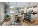Open-concept kitchen and dining area with modern pendant lighting, white cabinets, and stainless steel appliances at 6215 Barley Sq, Sugar Hill, GA 30518
