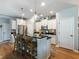 Bright kitchen with white cabinetry, stainless steel appliances, a large island with bar seating, and hardwood floors at 6215 Barley Sq, Sugar Hill, GA 30518