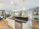 Spacious kitchen with a central island, dishwasher, and an open view of the living and dining areas at 6215 Barley Sq, Sugar Hill, GA 30518