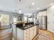 Stylish kitchen featuring stainless steel appliances, a central island, and pendant lighting, seamlessly connecting to the dining area at 6215 Barley Sq, Sugar Hill, GA 30518