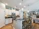 Well-lit kitchen with white cabinets, black countertops, stainless steel appliances, and a cozy breakfast bar at 6215 Barley Sq, Sugar Hill, GA 30518