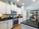 Well-lit kitchen boasts stainless steel appliances, black countertops, and white cabinetry at 6215 Barley Sq, Sugar Hill, GA 30518